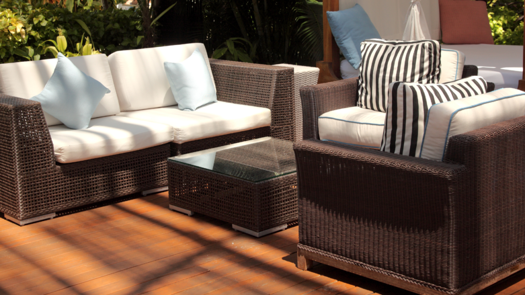 Boender Outdoor loungeset met witte kussens en blauwe en gestreepte sierkussens op een houten terras.