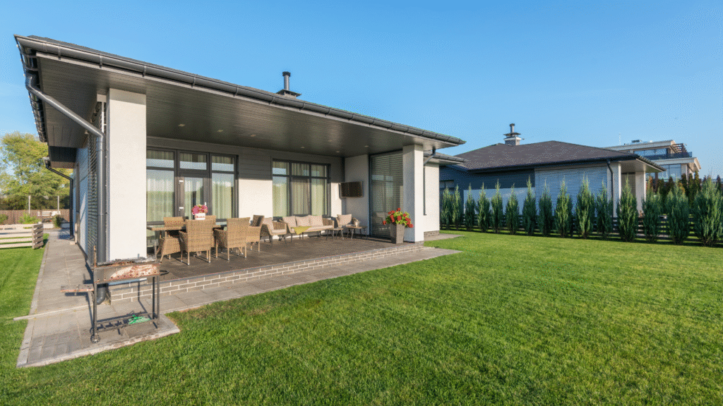 Moderne achtertuin met overdekt terras en stijlvolle tuinset