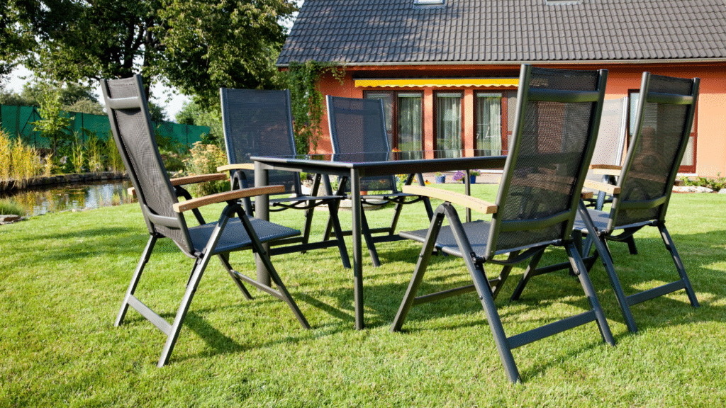 Moderne tuinset met glazen tafel en verstelbare stoelen op gazon