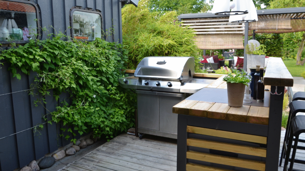moderne buitenkeuken met gasbarbecue en houten bar op een groen terras