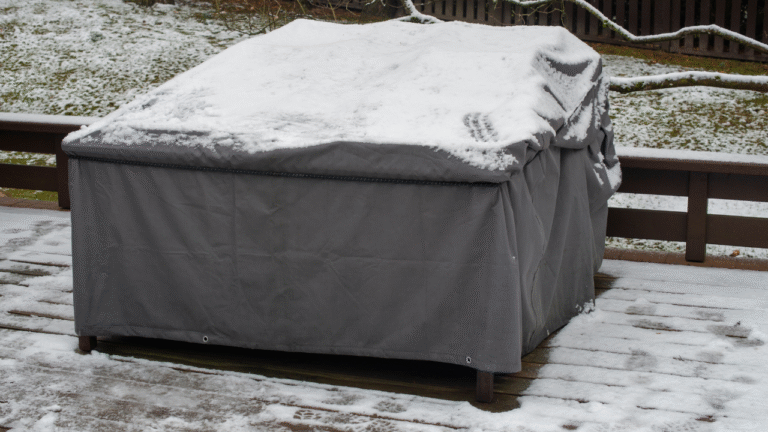 Tuinmeubelhoes bedekt met sneeuw op houten terras in de winter