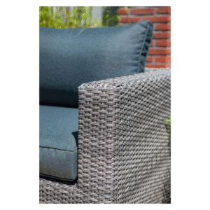 Detail van wicker armleuning met kussen in buitenomgeving