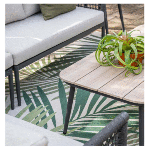 Detail van loungeset tafel met houten blad en decoratieve plant