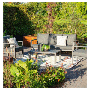 Loungeset op terras tussen kleurrijke tuinplanten in de zon