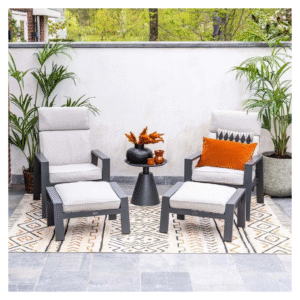 Valley Sand lounge stoelen met voetenbanken en oranje sierkussens op buitenkleed