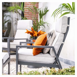 Zijaanzicht van lounge stoel met dikke kussens en oranje sierkussen op terras