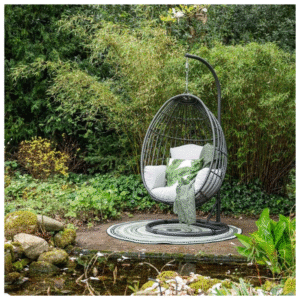 Eivormige Panama hangstoel met standaard en kussens in groene tuin